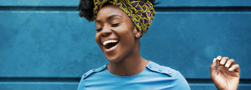 mulher vestindo azul rindo contra uma parede azul